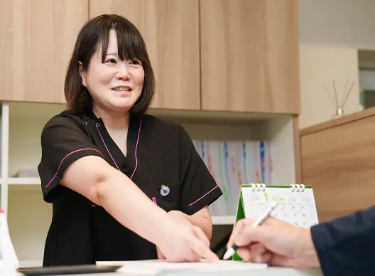 手続きのサポートをする女性スタッフの写真