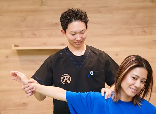 肩の動きを確認する施術スタッフの様子