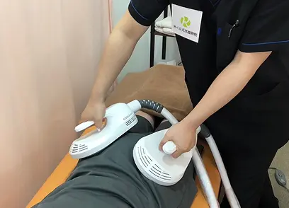 症状に応じた機器による施術を行っている様子